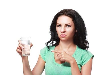 Frau zeigt auf Wasserglas